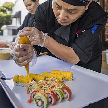Our skilled sushi chef artfully arranges fresh fish, rice and fillings with precision, all while maintaining a mesmerizing rhythm that captivates the hungry crowd.